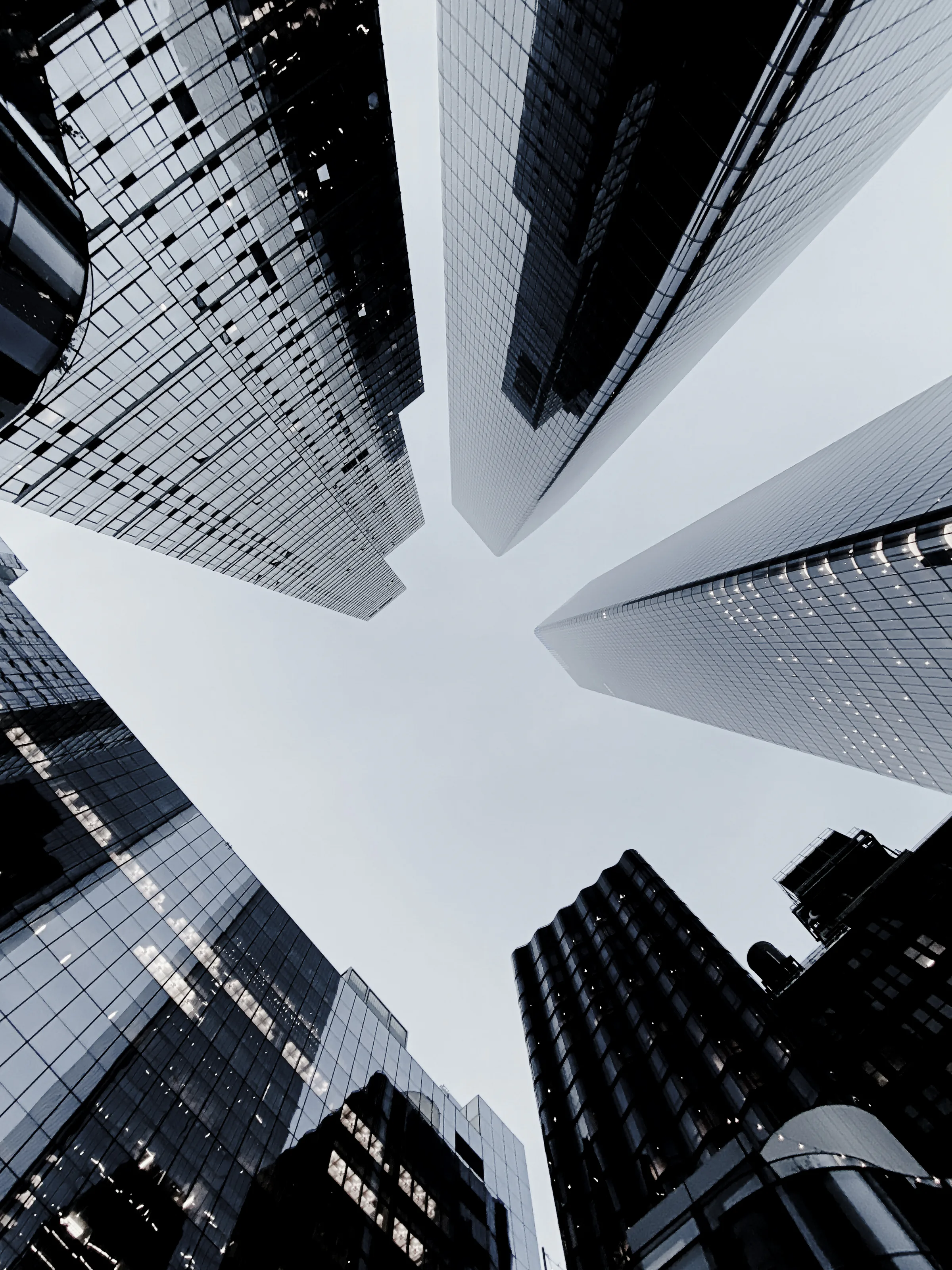 Black and white view looking upward between New York skyscrapers