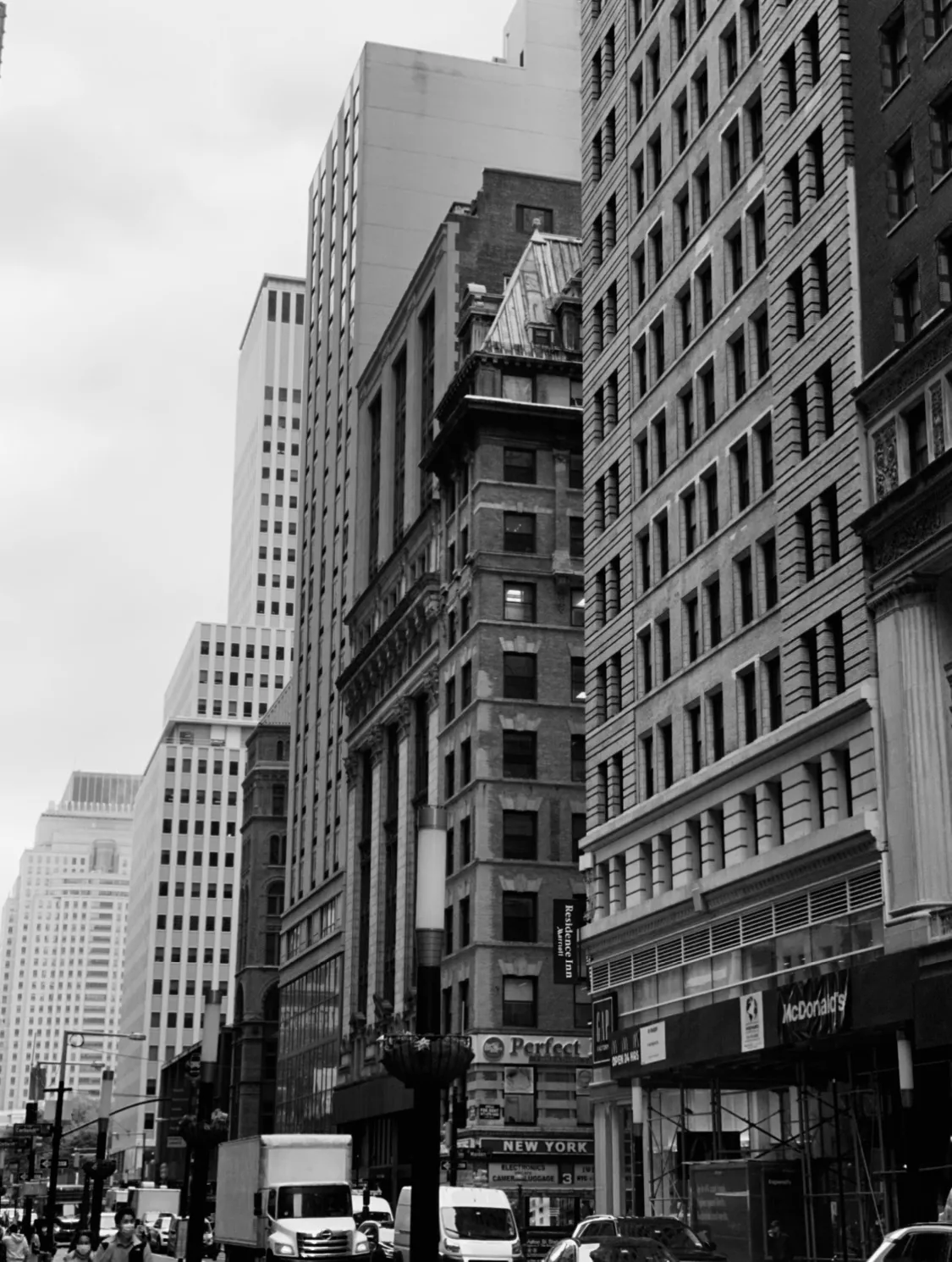 Black and white New York street framed by tall historic buildings