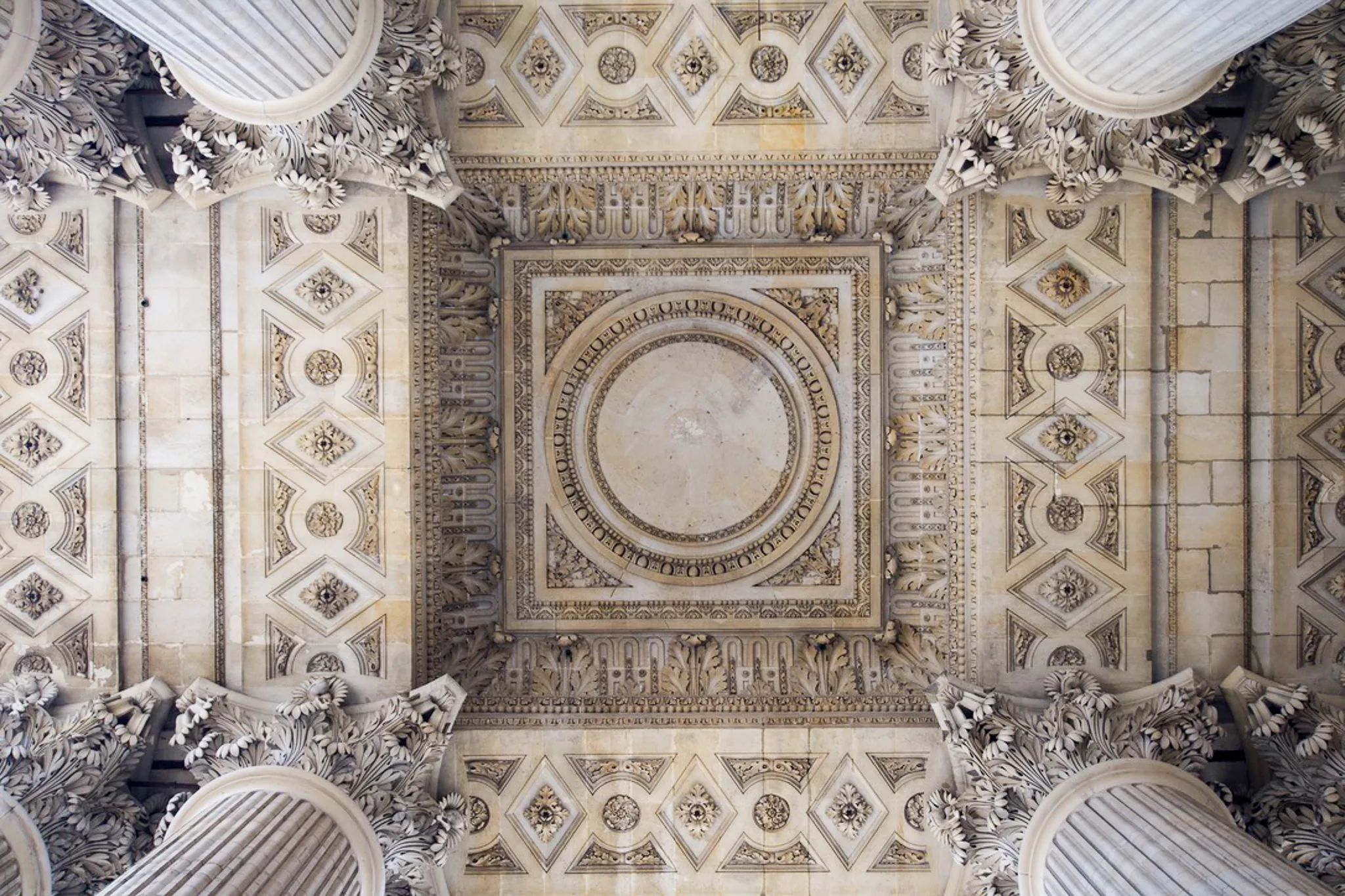 Symmetrical view of an ornate stone ceiling in Paris